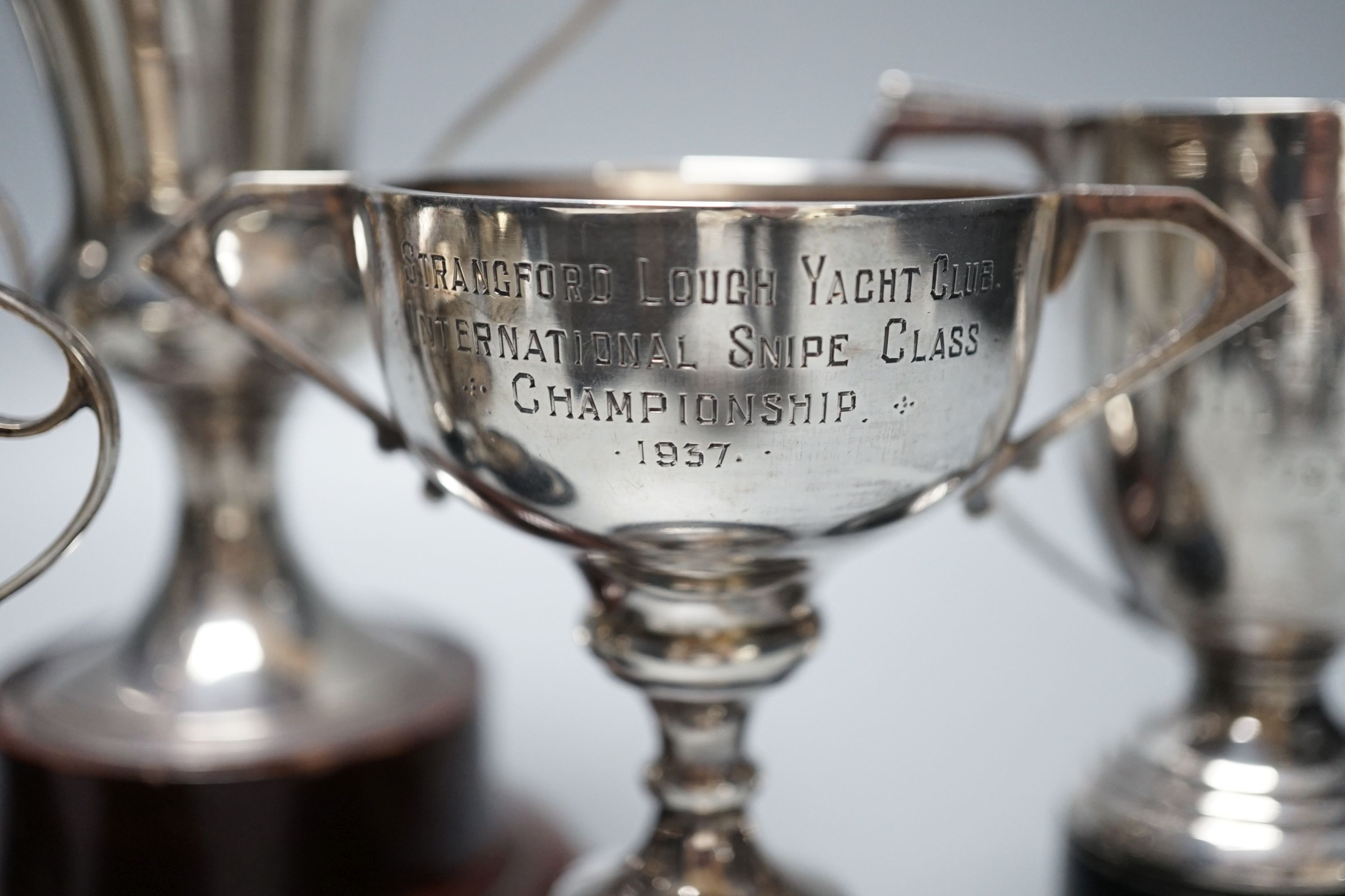 Five assorted 1920's/1930's silver two handled presentation trophy cups, all with engraved inscriptions and all with stands, largest 11.8cm.